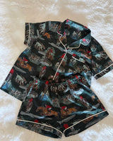 women's short satin pyjama set in forest green, featuring an exclusive hand-illustrated horse and hound print, short-sleeved button-up shirt, matching shorts and white piping.
